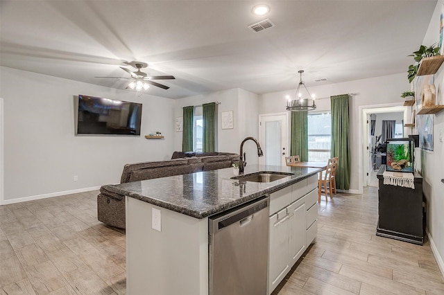 kitchen with pendant lighting, white cabinetry, an island with sink, sink, and stainless steel dishwasher