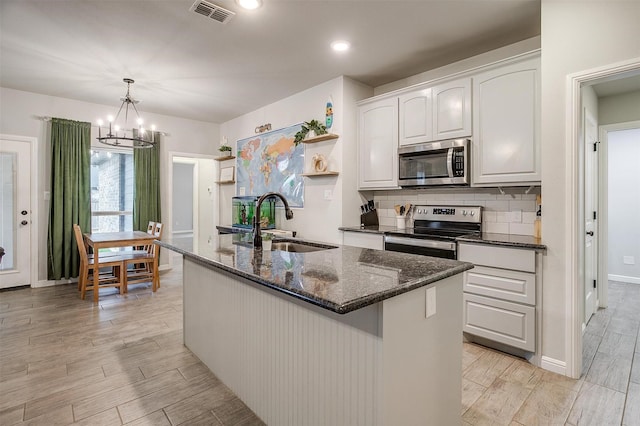 kitchen featuring pendant lighting, sink, white cabinets, a kitchen island with sink, and stainless steel appliances