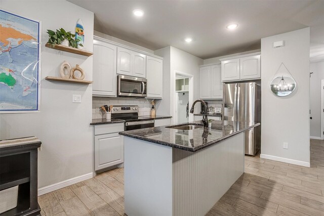 kitchen with sink, decorative backsplash, white cabinets, and appliances with stainless steel finishes