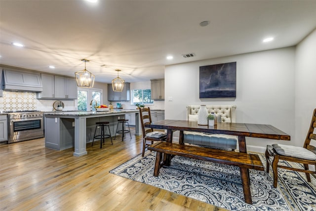 dining room featuring light wood-type flooring, visible vents, and recessed lighting