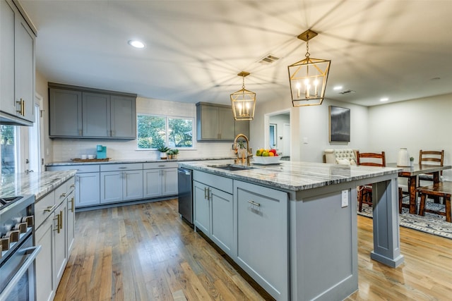 kitchen featuring tasteful backsplash, visible vents, hardwood / wood-style flooring, appliances with stainless steel finishes, and a sink