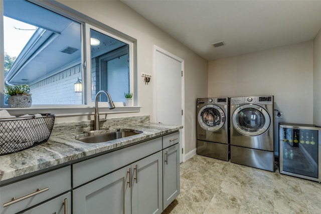 laundry room featuring cabinet space, visible vents, washer and clothes dryer, and a sink