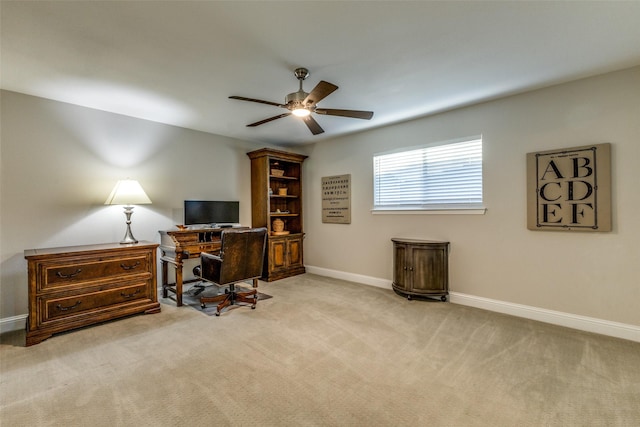 office area with a ceiling fan, carpet flooring, and baseboards