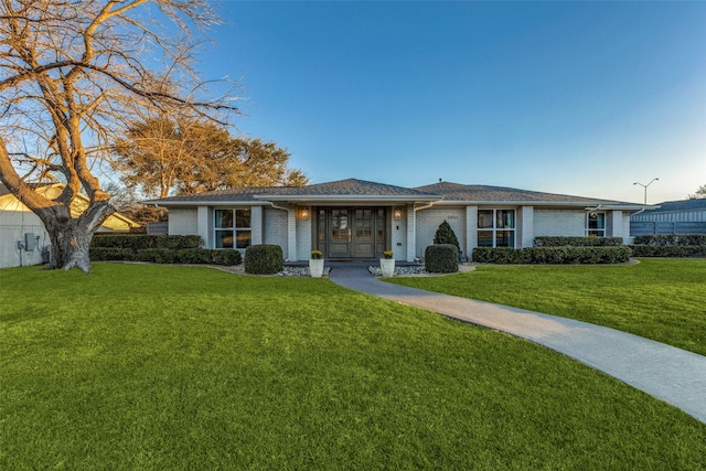 single story home with brick siding and a front lawn