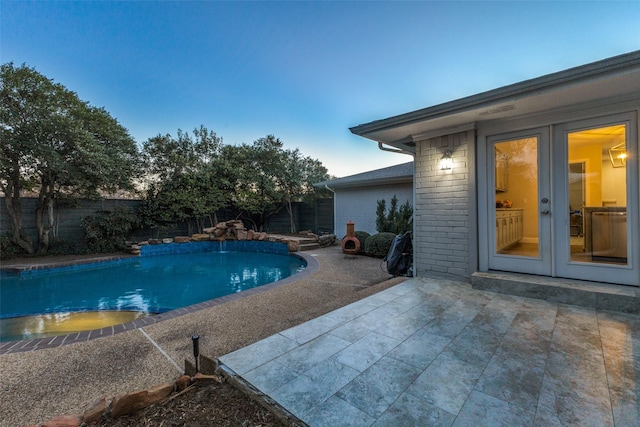 view of swimming pool with a fenced in pool, french doors, a fenced backyard, and a patio