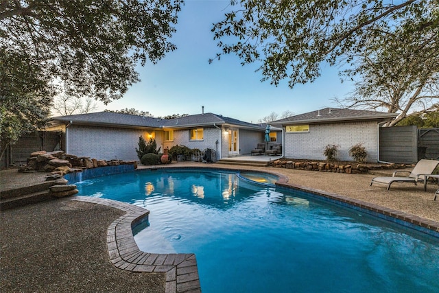 outdoor pool featuring a patio area and fence