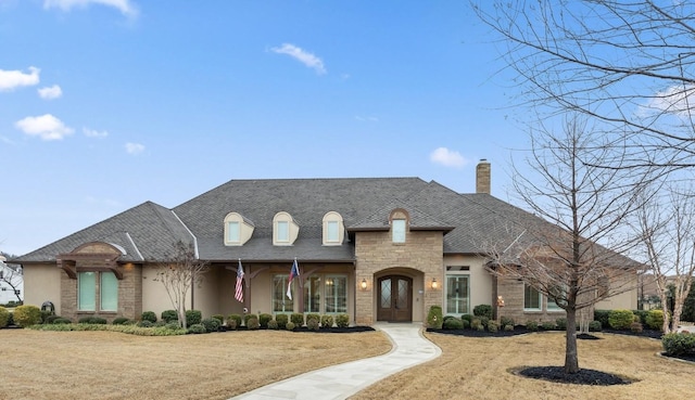 french provincial home with a front lawn