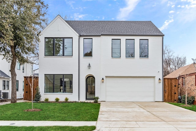 view of front of house with central AC unit, a garage, and a front lawn