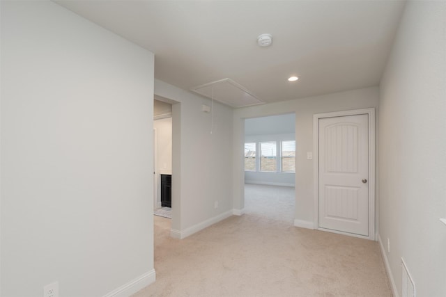 hallway featuring light colored carpet