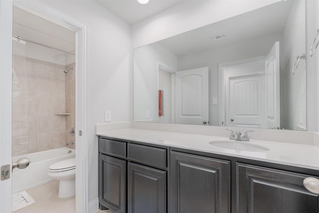 full bathroom with vanity, tile patterned flooring, tiled shower / bath combo, and toilet