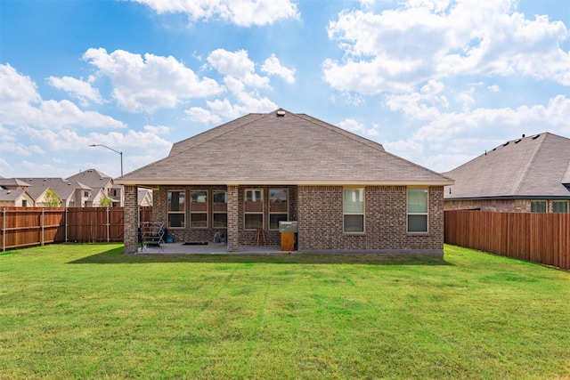 rear view of house featuring a yard and a patio area