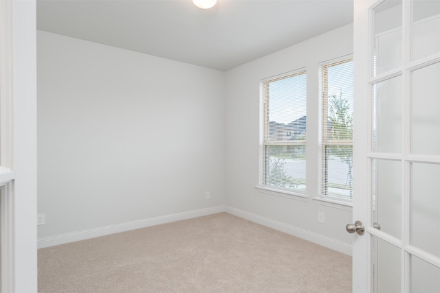 unfurnished room featuring light colored carpet