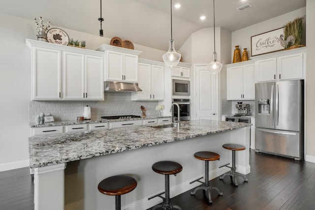 kitchen with sink, appliances with stainless steel finishes, a kitchen island with sink, hanging light fixtures, and white cabinets