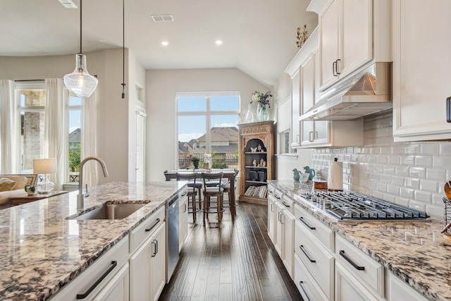 kitchen with appliances with stainless steel finishes, white cabinetry, sink, hanging light fixtures, and plenty of natural light