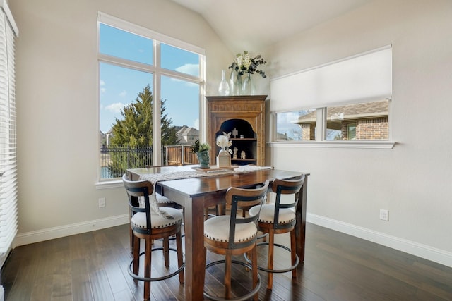 dining space featuring dark wood-type flooring and lofted ceiling