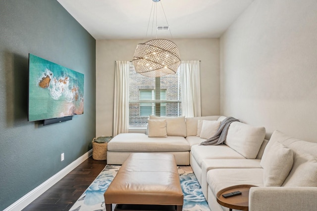 living room with dark hardwood / wood-style flooring and a chandelier