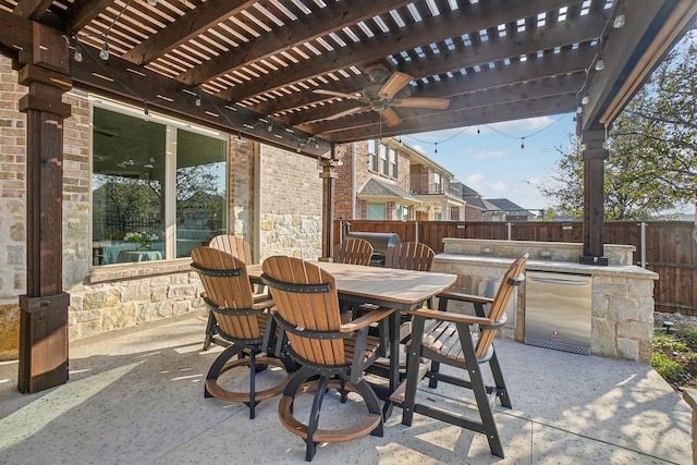 view of patio / terrace featuring an outdoor kitchen, an outdoor bar, ceiling fan, and a pergola