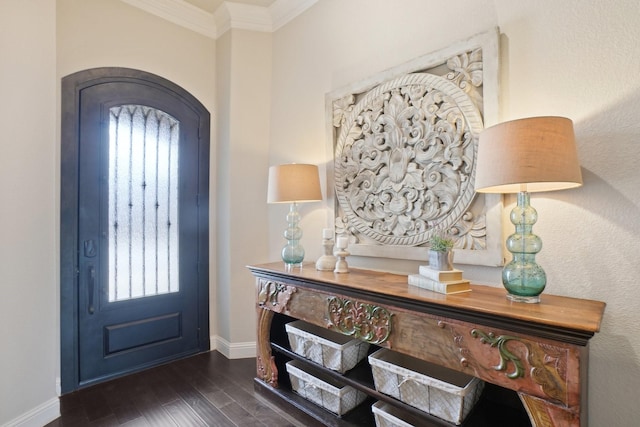 entryway with a wealth of natural light, dark wood-type flooring, and ornamental molding