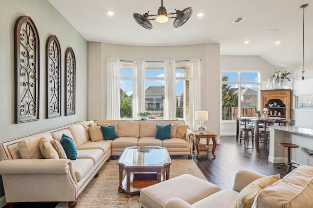 living room featuring dark wood-type flooring and ceiling fan