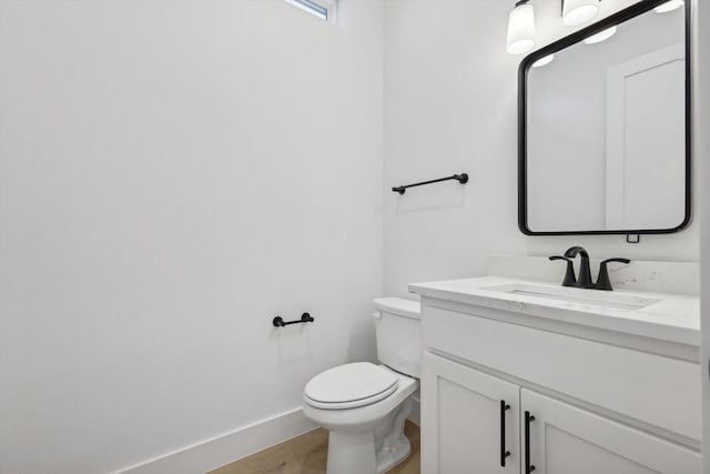 bathroom featuring hardwood / wood-style flooring, vanity, and toilet