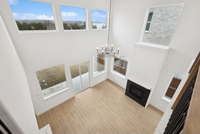 unfurnished living room featuring light hardwood / wood-style flooring and a notable chandelier