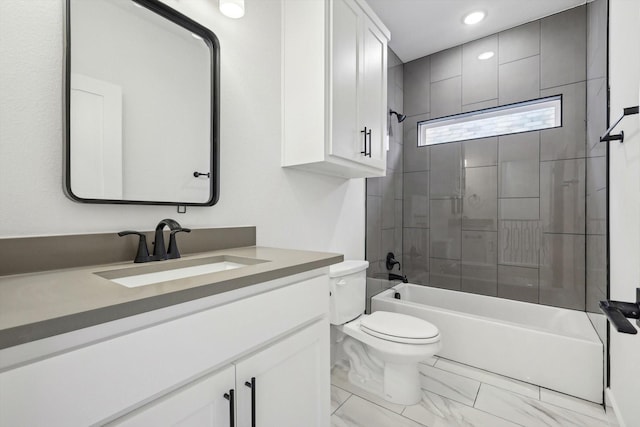 full bathroom featuring tiled shower / bath combo, vanity, and toilet