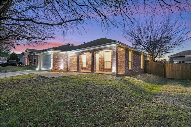 ranch-style home featuring a garage and a yard