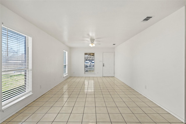 spare room with ceiling fan and light tile patterned floors