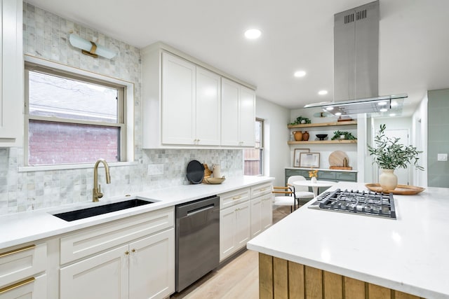 kitchen with island range hood, a sink, light countertops, appliances with stainless steel finishes, and open shelves