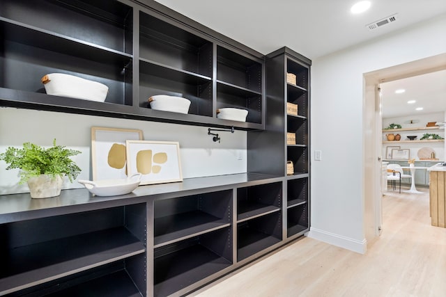 interior space with baseboards, visible vents, wood finished floors, and recessed lighting