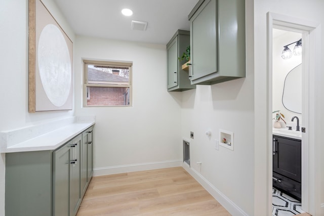 clothes washing area with gas dryer hookup, hookup for a washing machine, hookup for an electric dryer, baseboards, and cabinet space