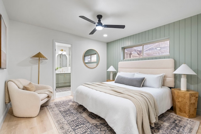 bedroom featuring a ceiling fan, connected bathroom, and wood finished floors