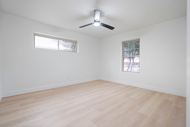 unfurnished room with light wood finished floors, a ceiling fan, a wealth of natural light, and baseboards