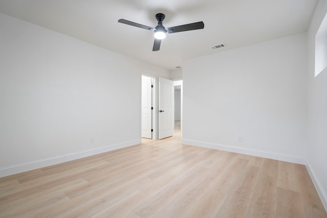 unfurnished room featuring visible vents, light wood-style flooring, and baseboards