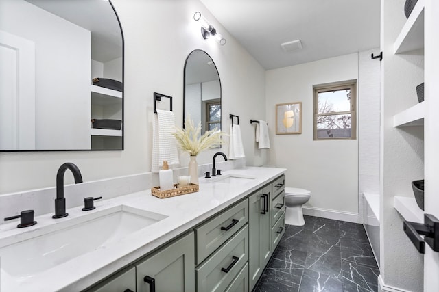 bathroom with marble finish floor, a sink, toilet, and baseboards