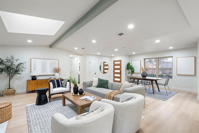 living room with vaulted ceiling with skylight, baseboards, light wood finished floors, and recessed lighting