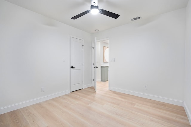 unfurnished room featuring baseboards, visible vents, and light wood-style floors