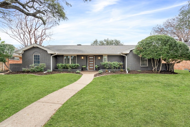 ranch-style house with a front lawn, roof with shingles, and brick siding