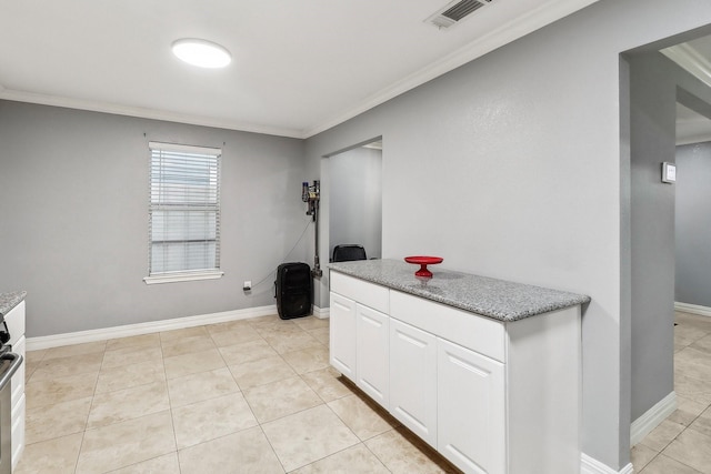 kitchen with white cabinetry, light tile patterned floors, and crown molding