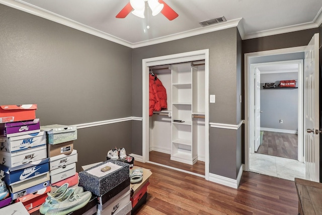 interior space featuring ornamental molding, dark hardwood / wood-style floors, ceiling fan, and a closet