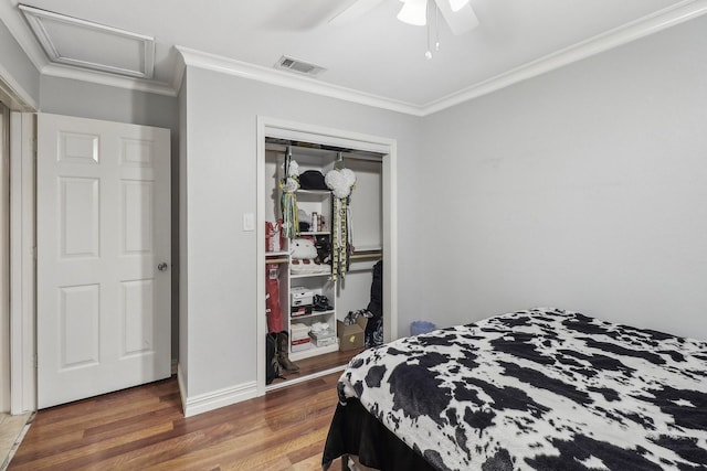 bedroom with dark hardwood / wood-style flooring, crown molding, a closet, and ceiling fan