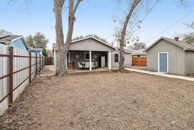 back of house with an outdoor structure and a patio