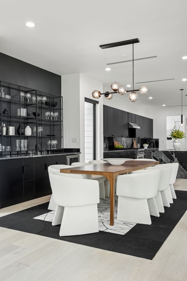 dining room with light hardwood / wood-style floors and indoor bar