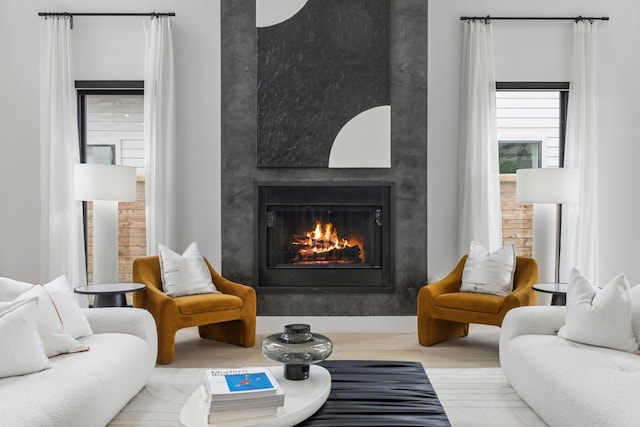 living area featuring a high end fireplace and light hardwood / wood-style flooring