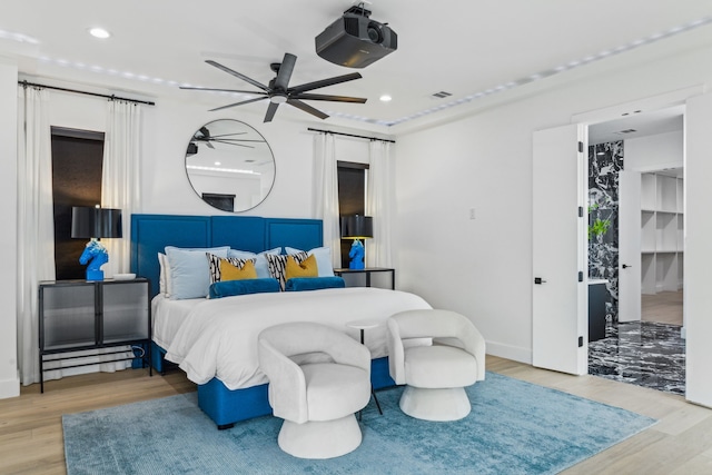 bedroom featuring a barn door and light wood-type flooring