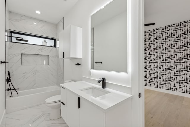 full bathroom with tiled shower / bath, vanity, and toilet