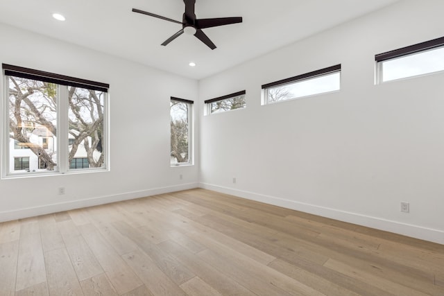 empty room featuring ceiling fan, a healthy amount of sunlight, and light wood-type flooring