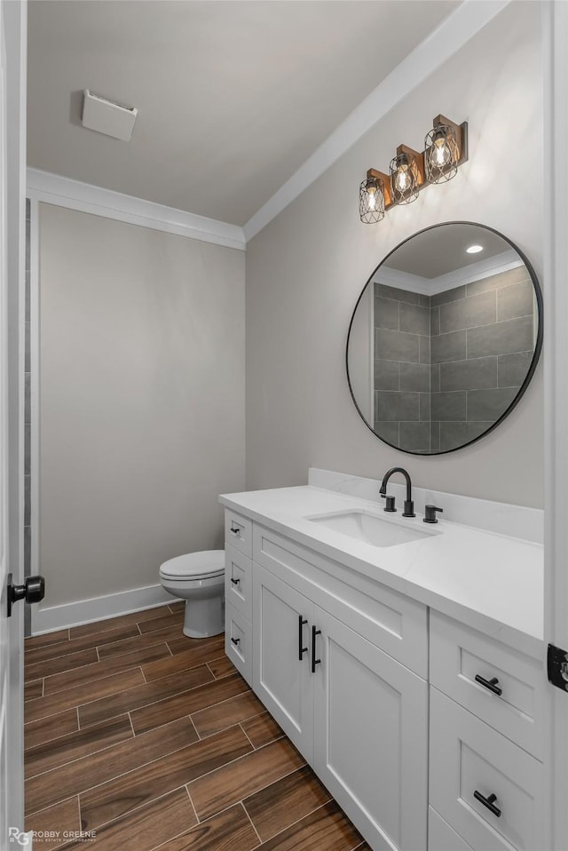 bathroom featuring crown molding, vanity, and toilet