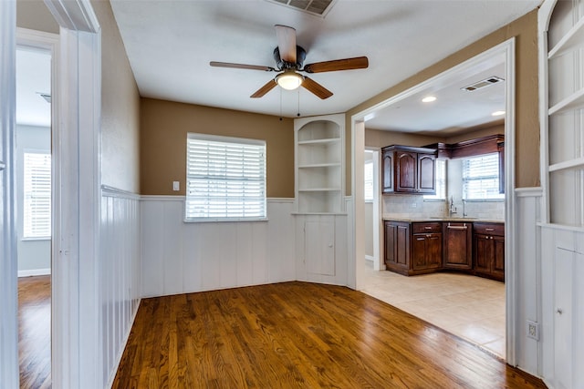 kitchen featuring sink, light hardwood / wood-style flooring, ceiling fan, and built in shelves