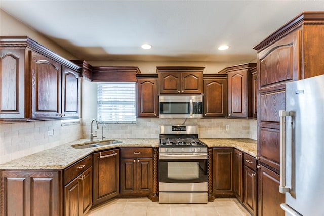 kitchen with appliances with stainless steel finishes, sink, light tile patterned floors, and decorative backsplash